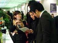 Visitatori asiatici Orientali alla fiera vinitali degustano vino